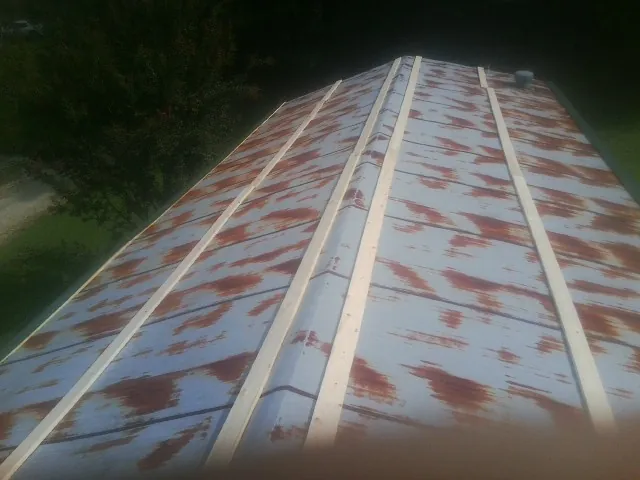 Rusted metal roof panels with new wood purlins before replacement — Storm Damage Roof Repair in Kempton by Roofing Brothers